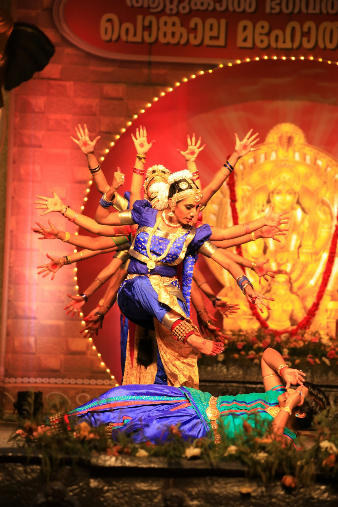 Dancers in traditional folk costumes perform on a stage.
